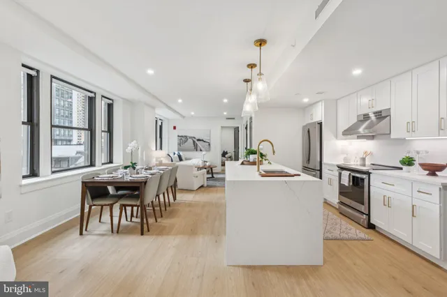 a living room with stainless steel appliances kitchen island granite countertop wooden floor a dining table and chairs