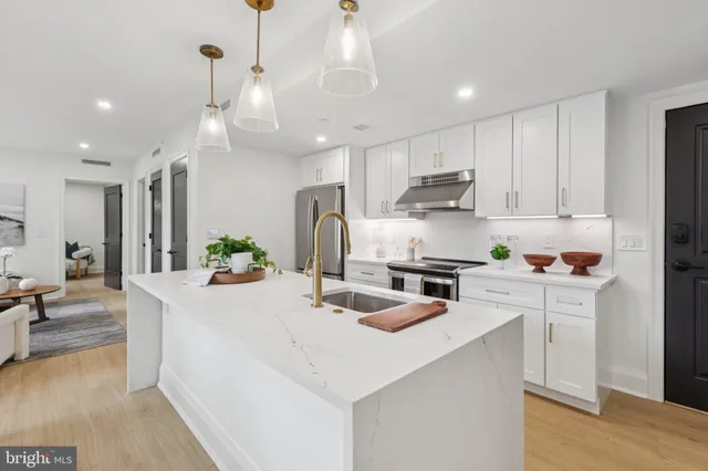 a kitchen with kitchen island white cabinets and refrigerator