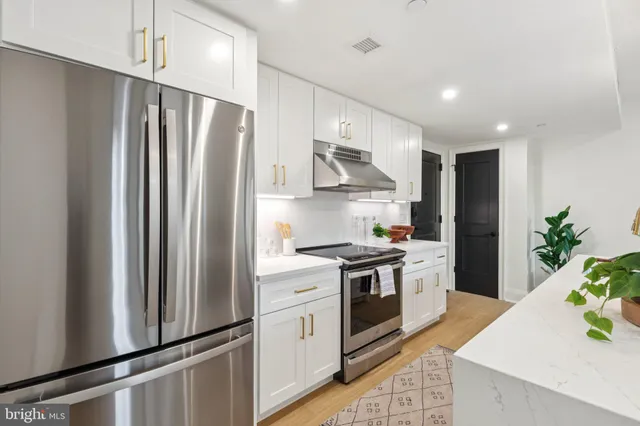 a kitchen with stainless steel appliances a refrigerator sink and stove
