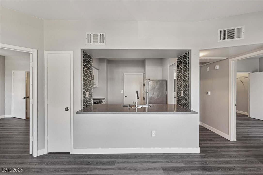 7255 West Sunset Road, Unit 1087 Las Vegas, NV 89113 - Photo 13 of 43 Kitchen with dark wood-style floors, freestanding refrigerator, and a peninsula