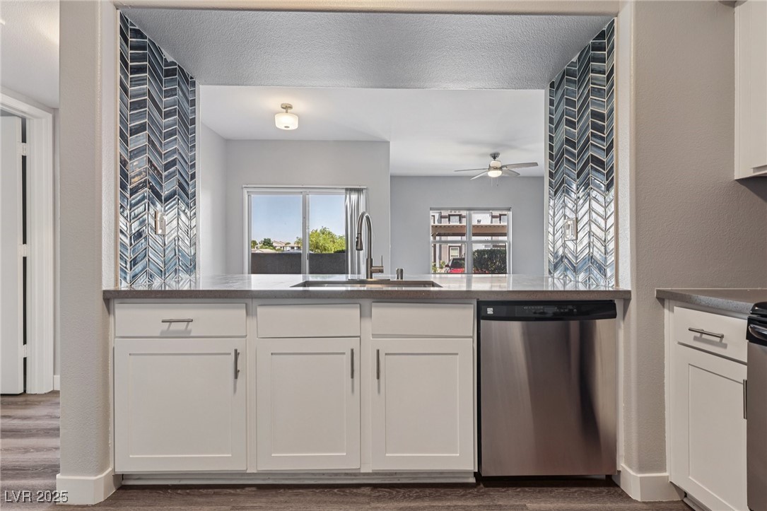 7255 West Sunset Road, Unit 1087 Las Vegas, NV 89113 - Photo 21 of 43 Kitchen featuring white cabinetry, dishwasher, dark wood-style floors, and a textured wall