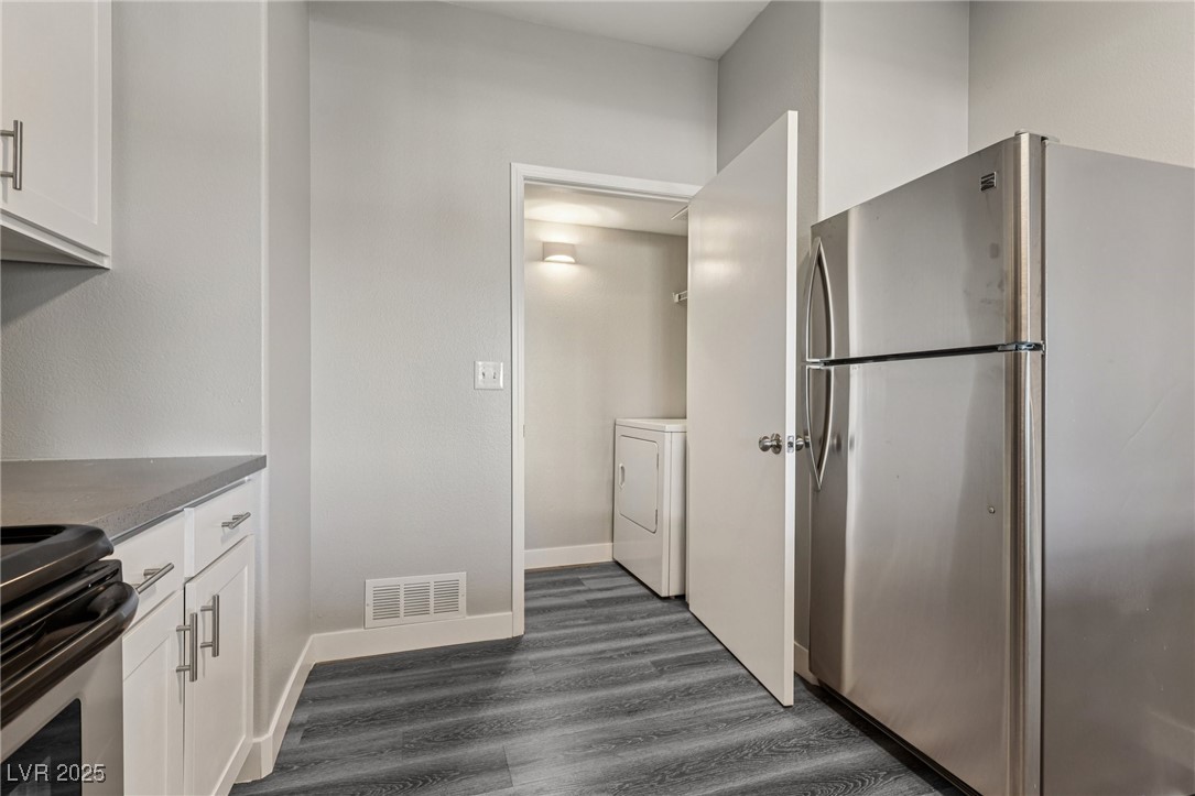 7255 West Sunset Road, Unit 1087 Las Vegas, NV 89113 - Photo 24 of 43 Kitchen featuring stainless steel appliances, white cabinets, dark wood finished floors, and dark stone counters
