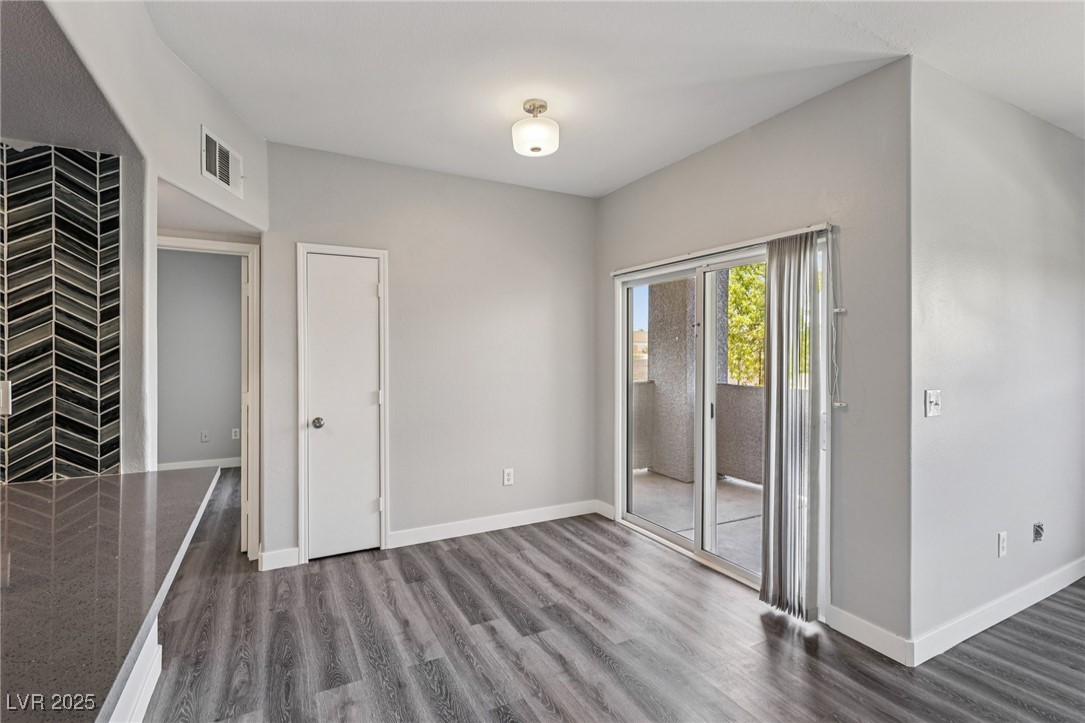 7255 West Sunset Road, Unit 1087 Las Vegas, NV 89113 - Photo 8 of 43 Unfurnished bedroom with dark wood-style floors and access to exterior