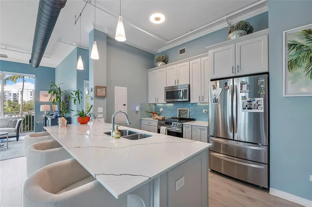 a kitchen with stainless steel appliances a sink and a refrigerator