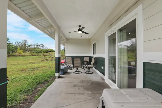 a living room with patio furniture and a floor to ceiling window
