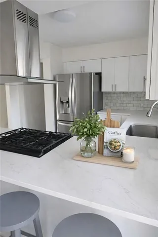 a kitchen with a refrigerator and a stove top oven