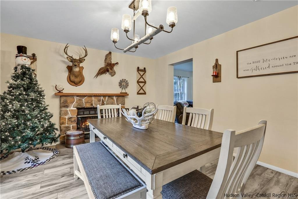 262 Potic Mountain Road Catskill, NY 12414 - Photo 8 of 30 a dining room with wooden floor a chandelier a wooden table and chairs