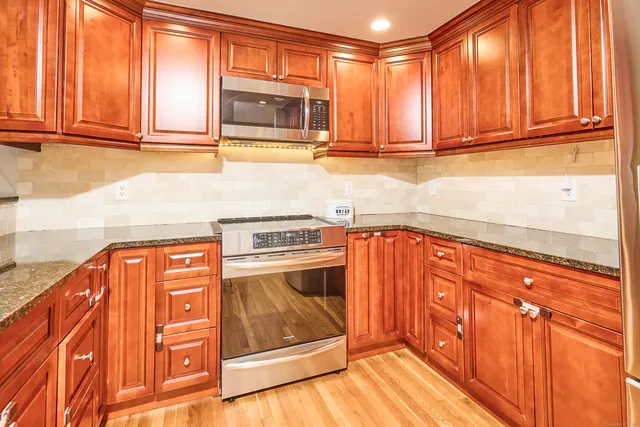 a kitchen with stainless steel appliances granite countertop a refrigerator and cabinets