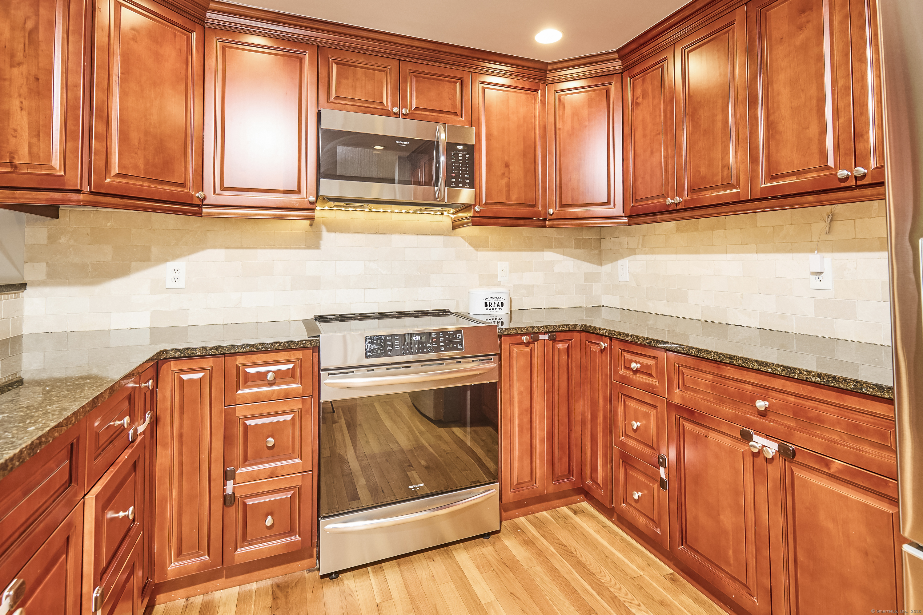 4 Colony Road Weston, CT 06883 - Photo 12 of 39 a kitchen with stainless steel appliances granite countertop a refrigerator and cabinets