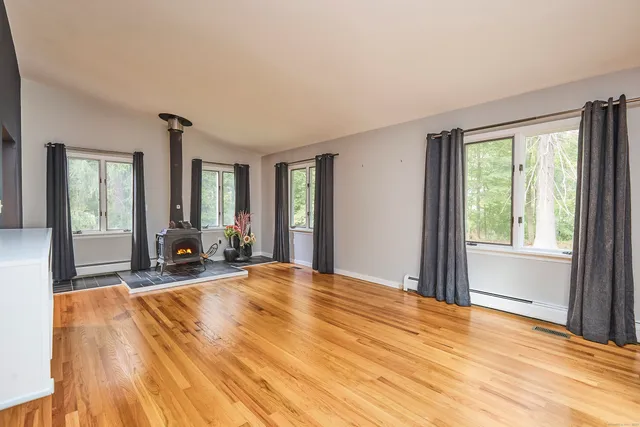 a view of a livingroom with wooden floor and windows