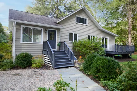 a view of a house with backyard and wooden fence