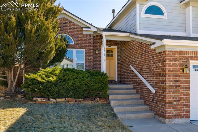 7827 Swiftrun Road Colorado Springs, CO 80920 - Photo 48 of 48 Doorway to property with a garage and brick siding