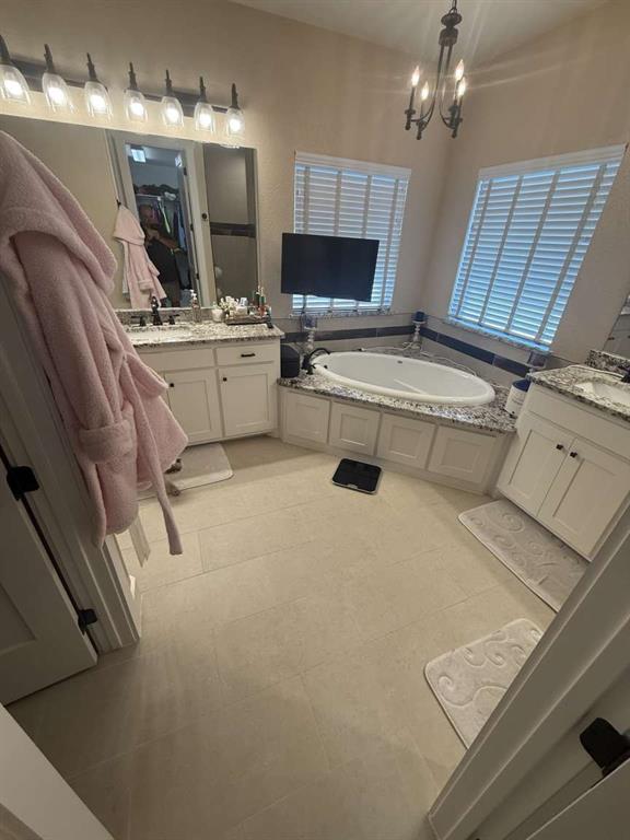 125 Lucky Ridge Lane Boyd, TX 76023 - Photo 11 of 29 Bathroom with two vanities, a bath, a chandelier, and tile patterned floors