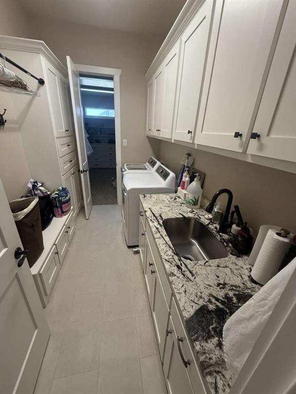 125 Lucky Ridge Lane Boyd, TX 76023 - Photo 15 of 29 Laundry room featuring cabinet space, washing machine and dryer, and light tile patterned floors