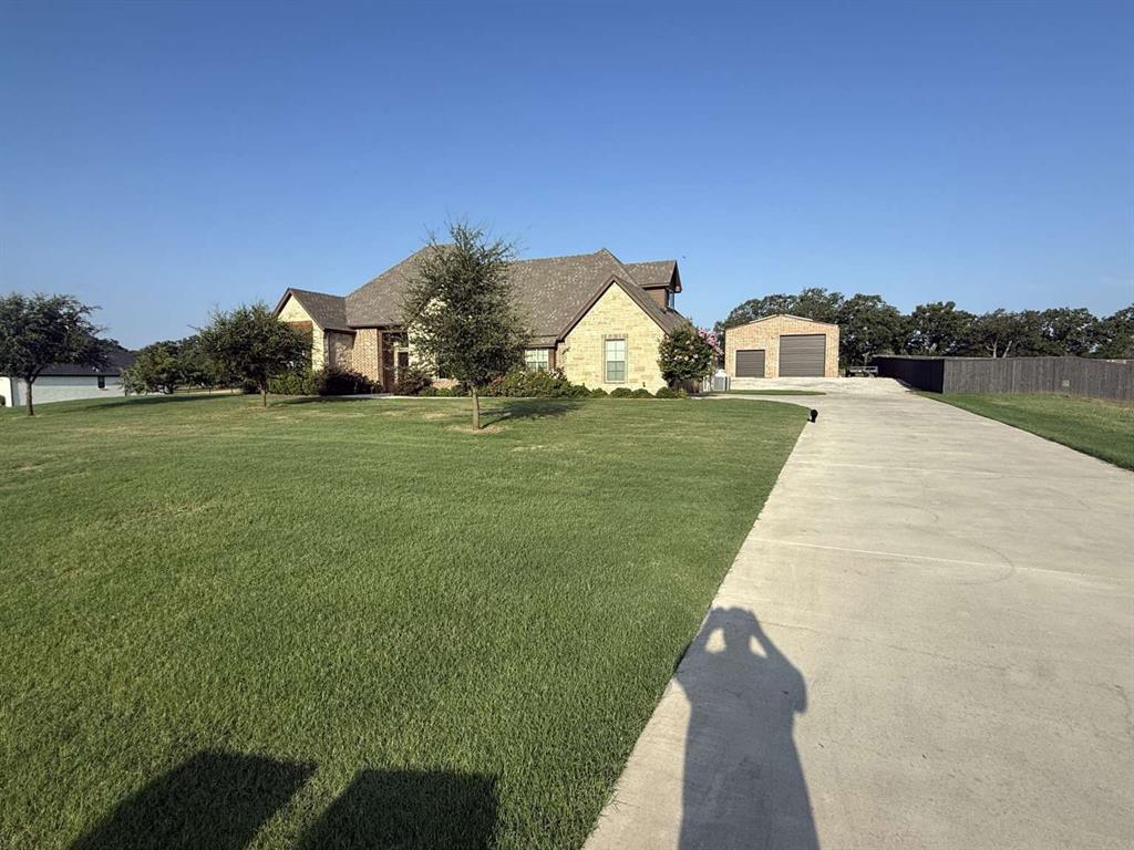125 Lucky Ridge Lane Boyd, TX 76023 - Photo 3 of 29 French provincial home with stone siding, an outbuilding, a detached garage, and driveway