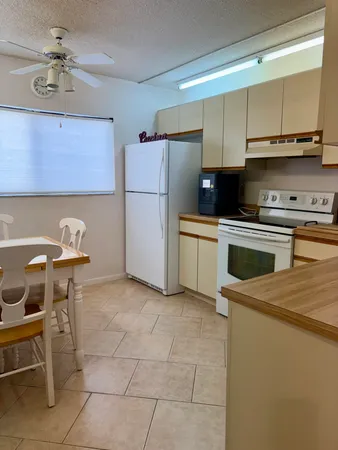 a kitchen with white cabinets appliances and a sink
