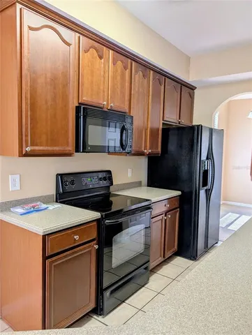 a kitchen with granite countertop a stove a refrigerator and a sink