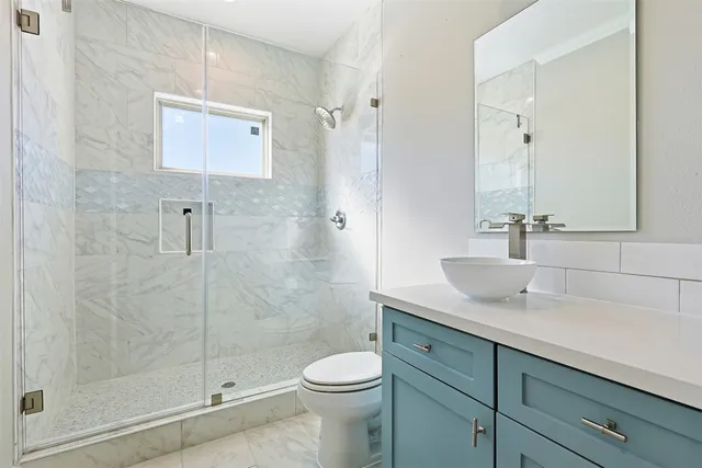 a bathroom with a sink a toilet and shower