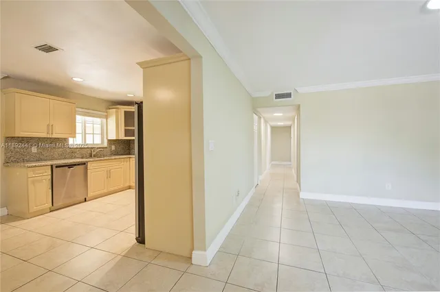 a view of a kitchen with an empty space and a window
