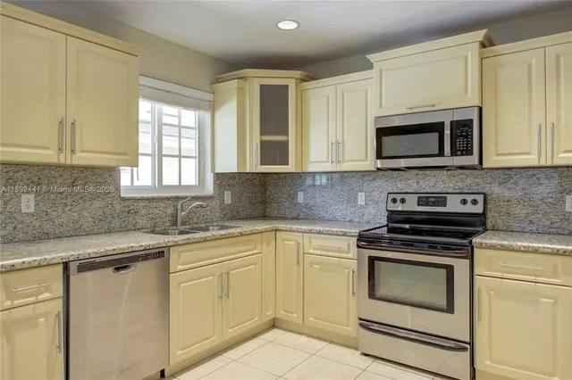 a kitchen with cabinets stainless steel appliances and window