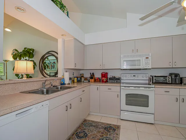 a kitchen with cabinets stainless steel appliances a sink and a stove