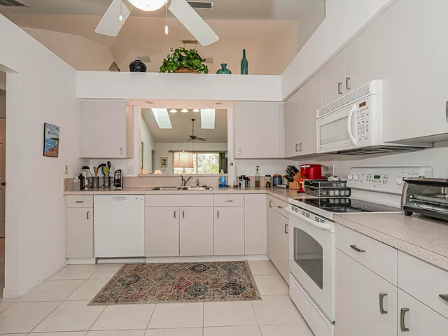 a kitchen with sink cabinets and white appliances