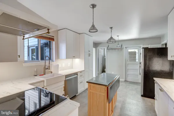 a kitchen with stainless steel appliances granite countertop a sink refrigerator and cabinets