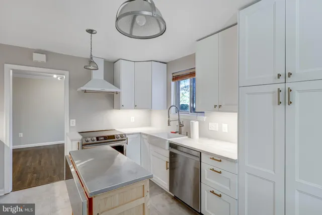 a kitchen with cabinets stainless steel appliances a sink and a stove