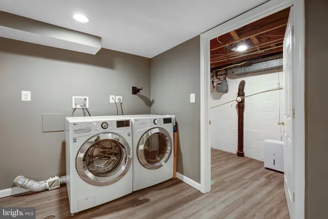 a utility room with wooden floor washer and dryer