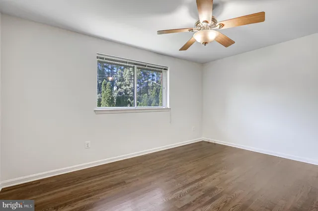 wooden floor in an empty room with a window