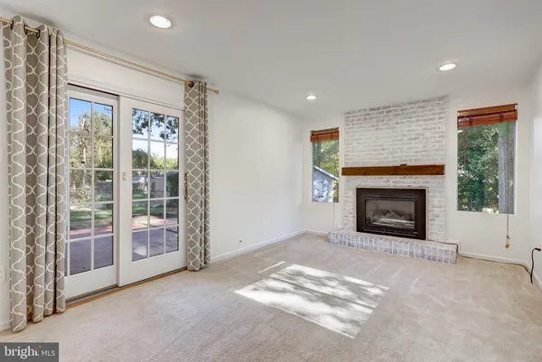 a view of an empty room with a fireplace and a window
