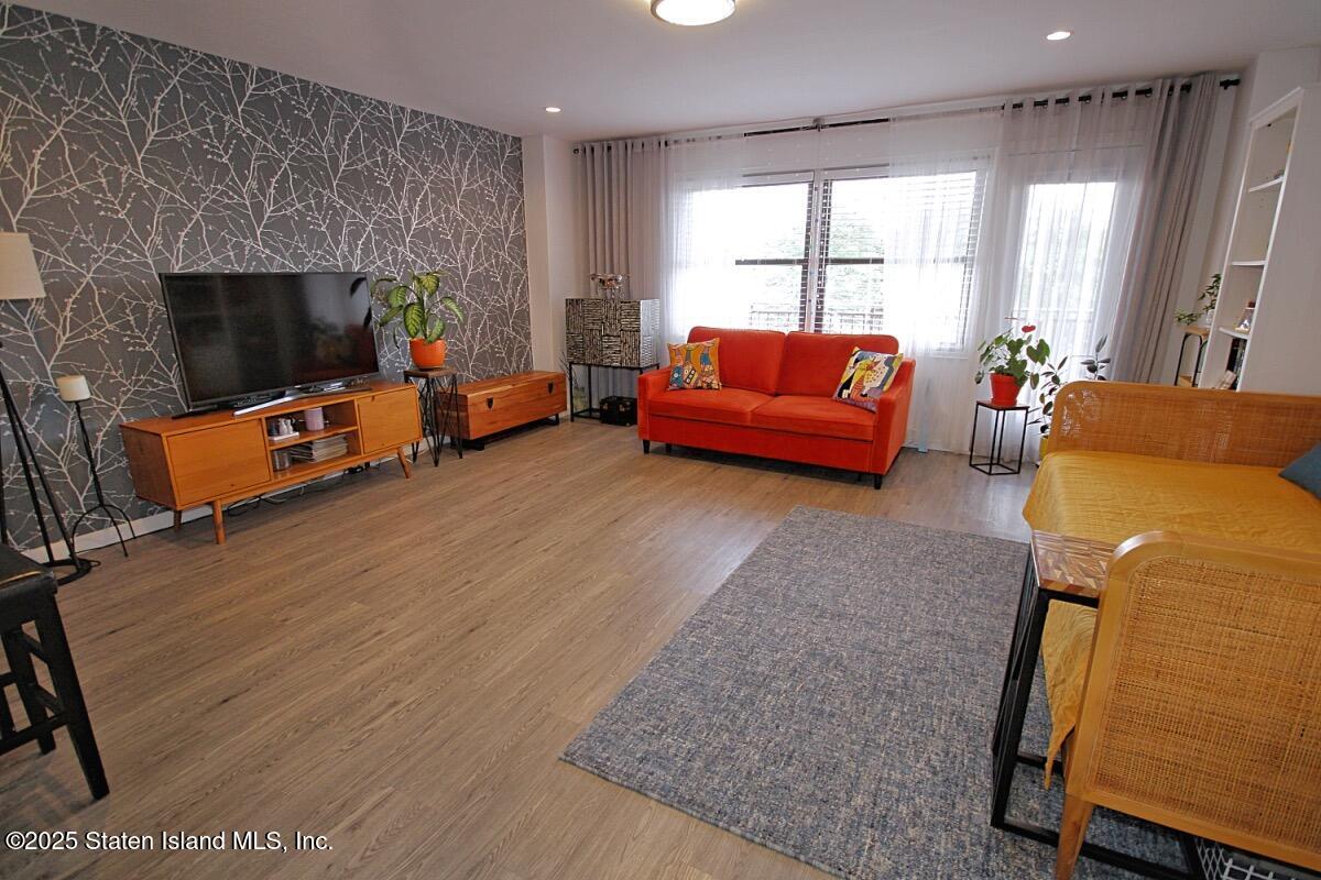 1000 Clove Road, Unit 7G Staten Island, NY 10301 - Photo 2 of 16 a living room with furniture a flat screen tv and a fireplace