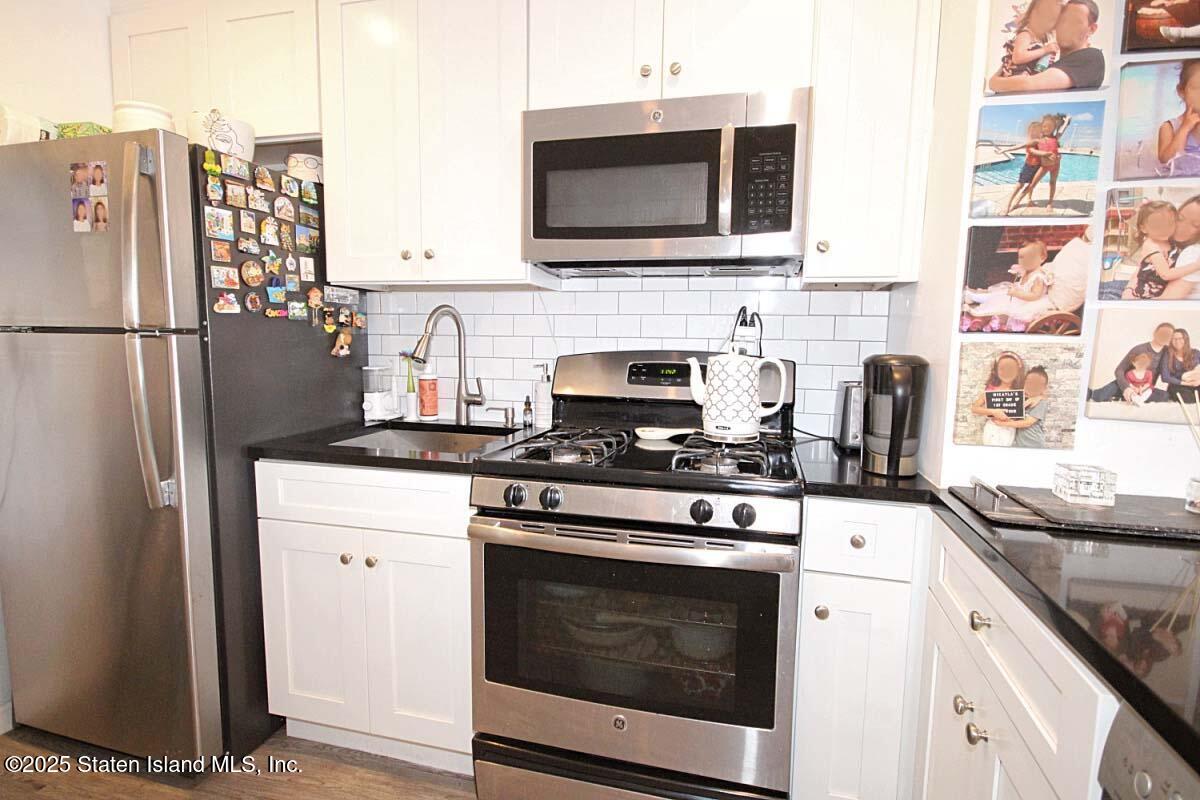 1000 Clove Road, Unit 7G Staten Island, NY 10301 - Photo 6 of 16 a kitchen with stainless steel appliances granite countertop a stove microwave and refrigerator