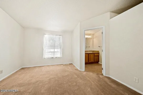 a big room with windows and a kitchen view