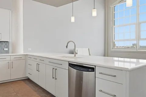 a kitchen with white cabinets and a sink