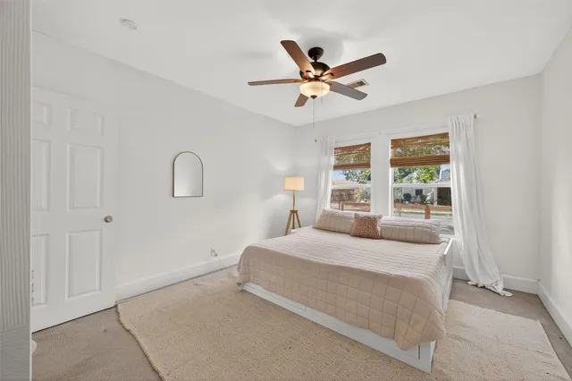 a bedroom with a bed and a ceiling fan