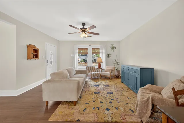 a living room with furniture and a wooden floor