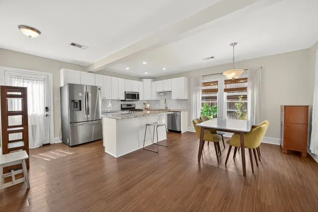 a kitchen with a table chairs a sink dishwasher window and cabinets