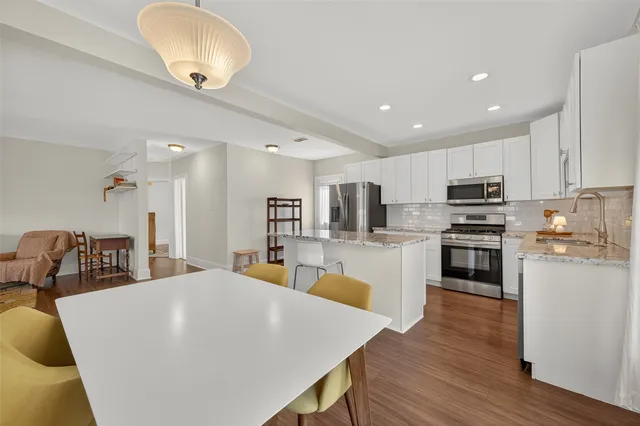 a kitchen with granite countertop a sink stove and cabinets