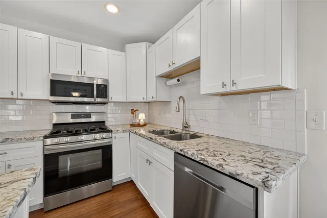 a bathroom with a granite countertop shower a sink and toilet