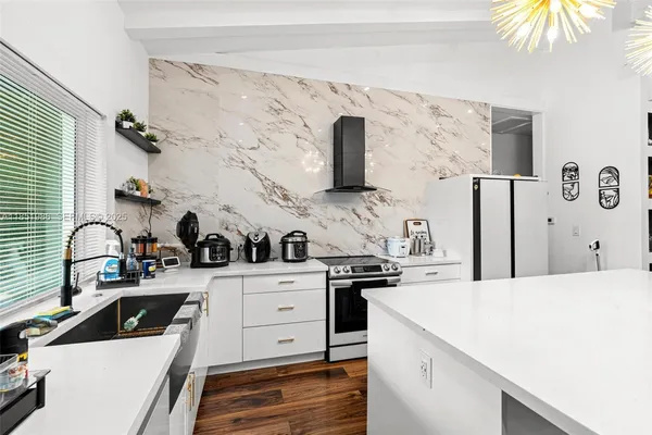 a kitchen with granite countertop a sink stainless steel appliances and cabinets