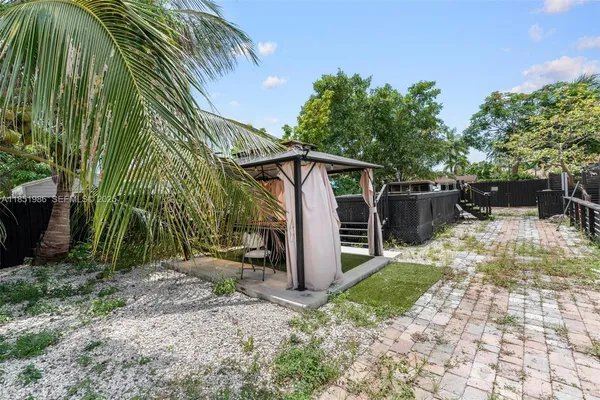 a view of a patio with a table and chairs under an umbrella