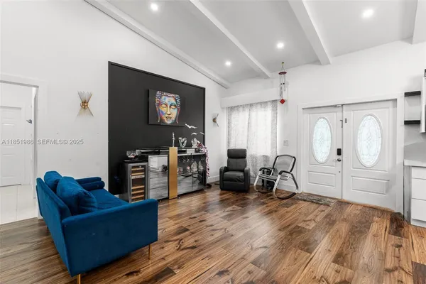 a living room with furniture a piano and a flat screen tv