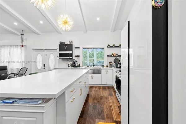 a large white kitchen with a stove a sink and a refrigerator