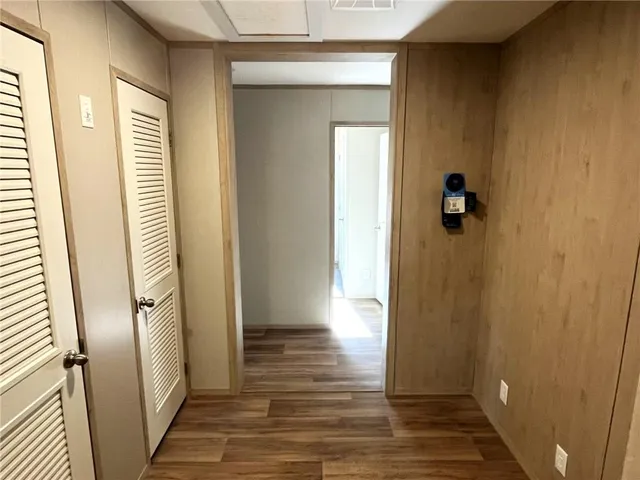 a view of a hallway with wooden floor and staircase