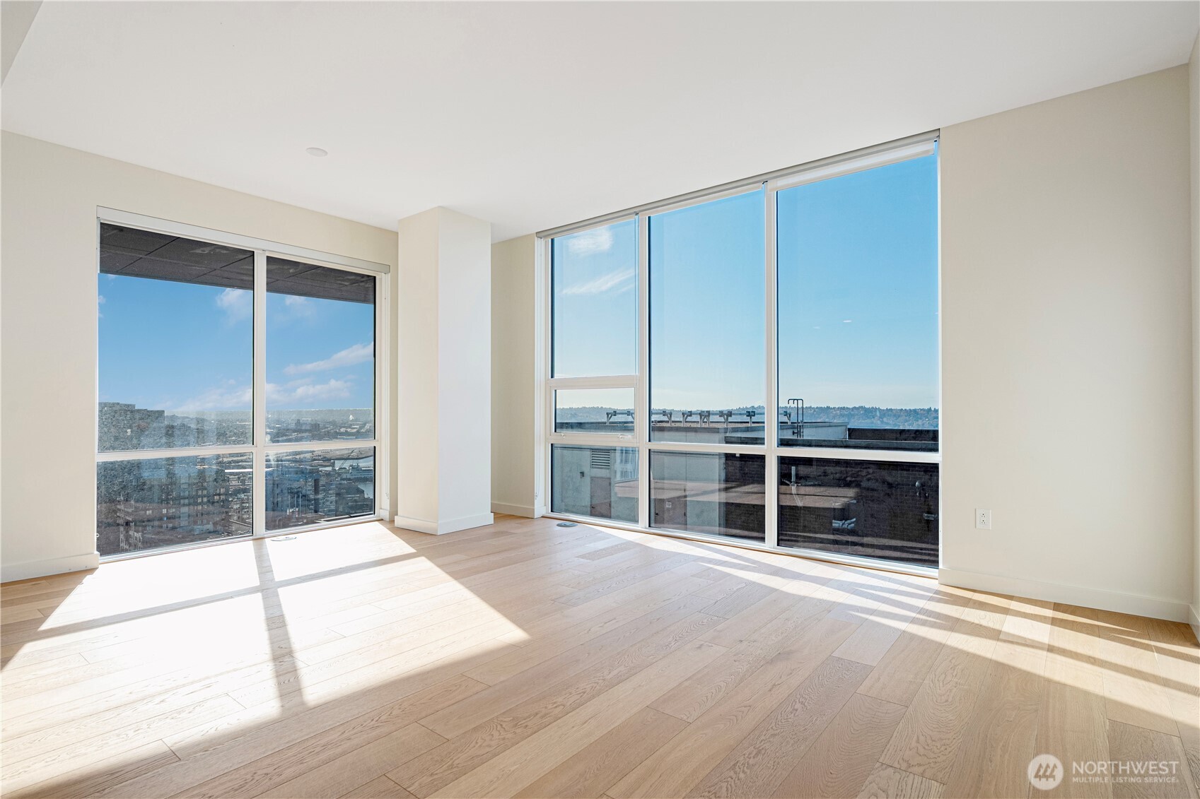 121 Stewart Street, Unit 1605 Seattle, WA 98101 - Photo 3 of 38 an empty room with wooden floor and windows