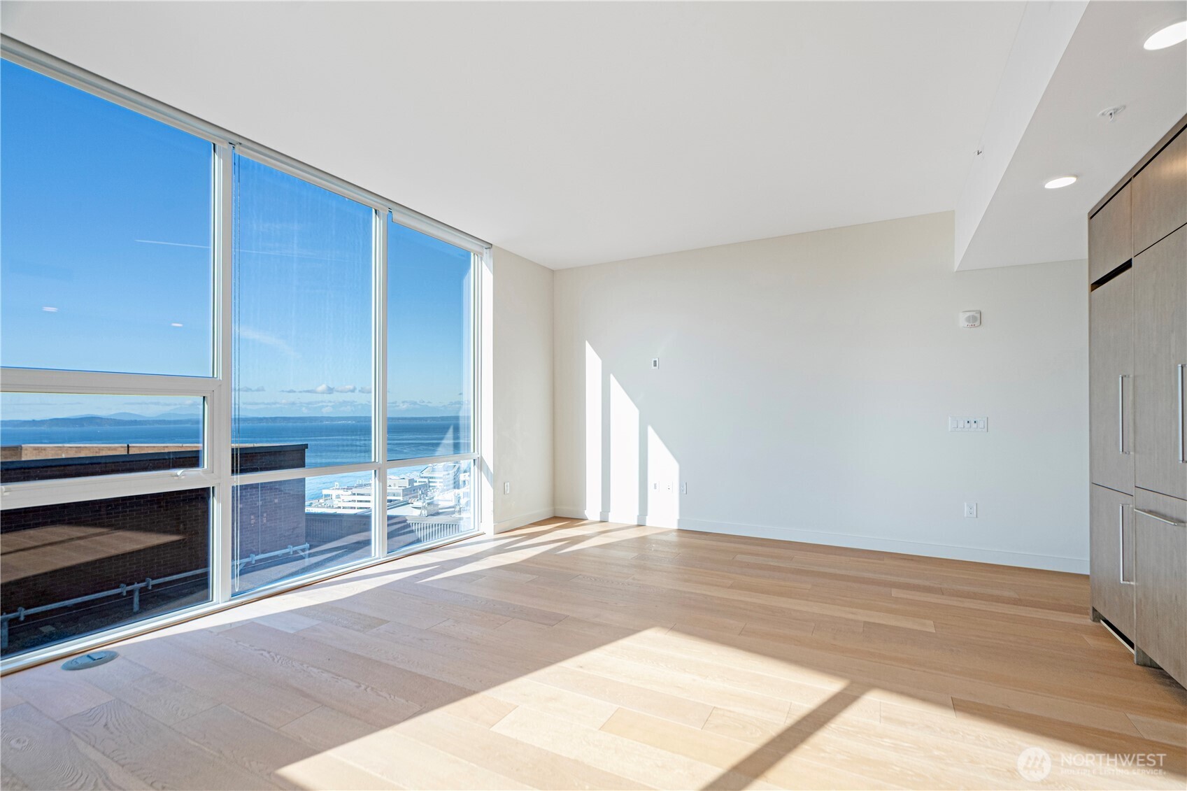 121 Stewart Street, Unit 1605 Seattle, WA 98101 - Photo 4 of 38 a view of a big room with wooden floor closet and windows