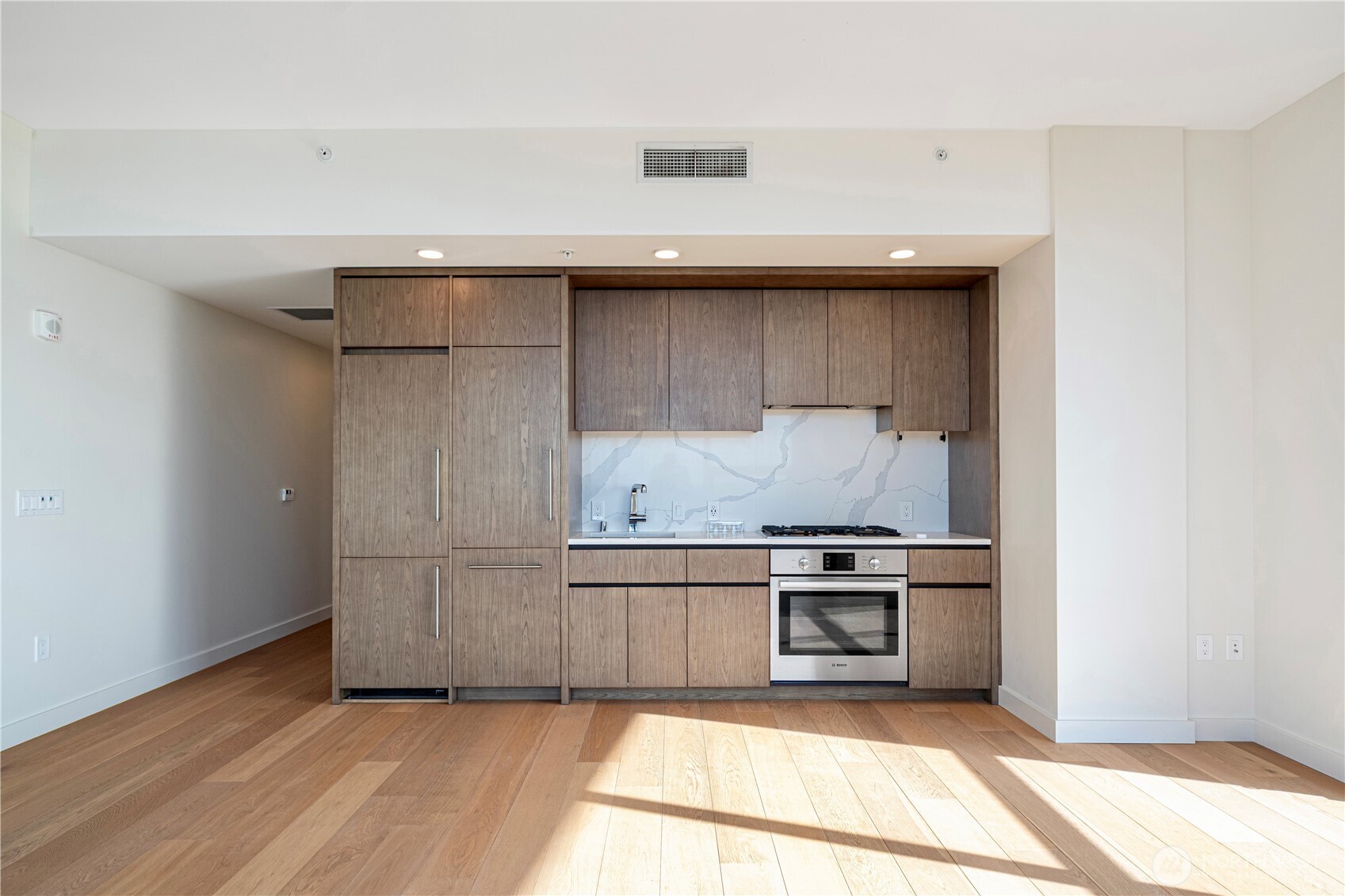 121 Stewart Street, Unit 1605 Seattle, WA 98101 - Photo 7 of 38 a kitchen with granite countertop white cabinets and stainless steel appliances