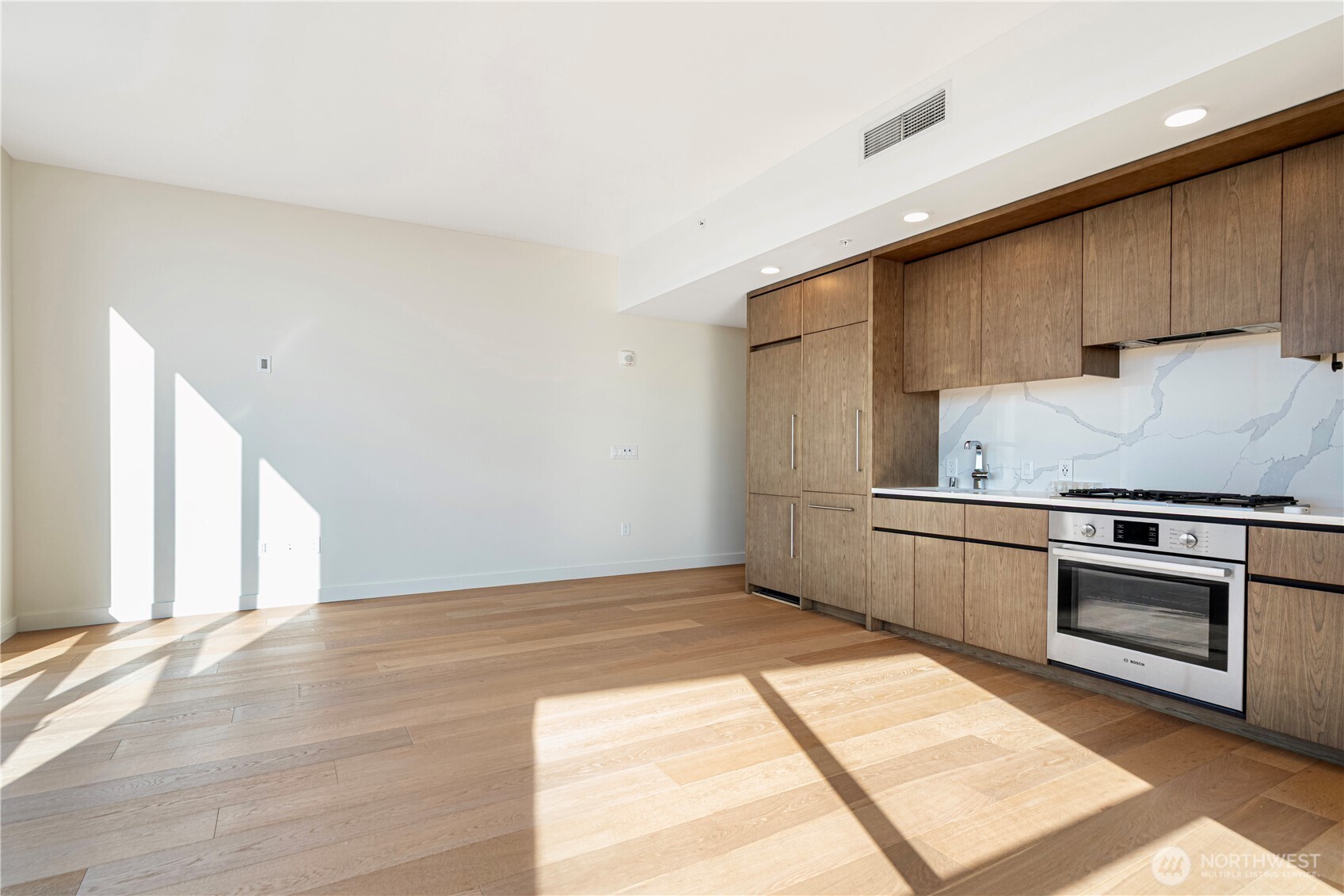 121 Stewart Street, Unit 1605 Seattle, WA 98101 - Photo 9 of 38 a kitchen with granite countertop a stove a sink and a microwave