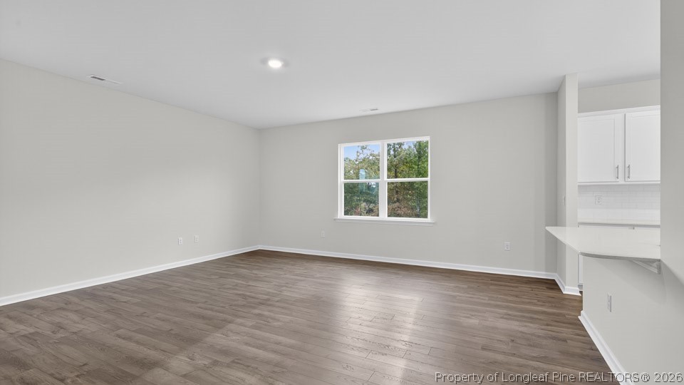194 Fair Child Road Spring Lake, NC 28390 - Photo 14 of 33 an empty room with wooden floor and windows